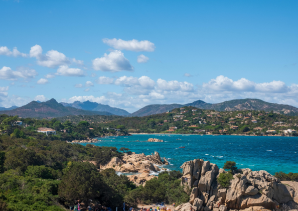 Paysage côtier de Sardaigne avec rochers granitiques, mer bleu intense et végétation méditerranéenne.